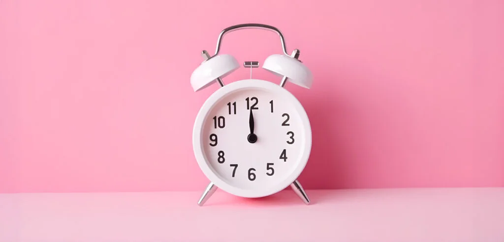 A clock on a pink background